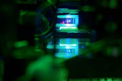 Glass cell with a cloud of laser-cooled strontium atoms hovering above a high-resolution microscope objective in our experiment at the Max Planck Institute of Quantum Optics.