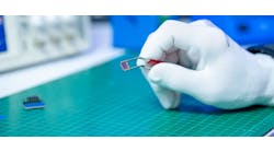 Image of gloved hand holding chip
