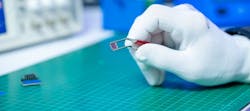 Image of gloved hand holding chip