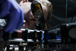 Ph.D. student Leevi Kallioniemi from NTU Singapore’s School of Physical & Mathematical Sciences with a blue laser setup for generating entangled photon pairs.